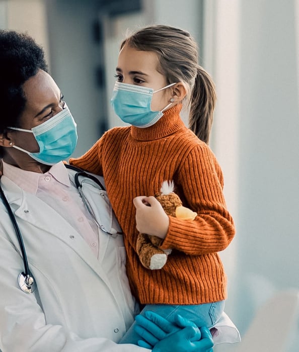 A clinician holding a child patient